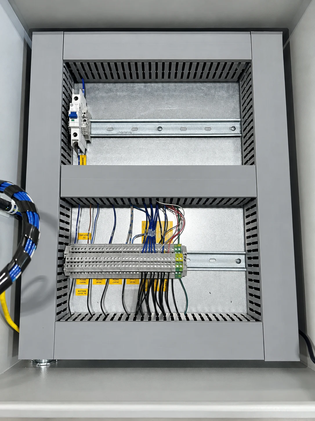 Terminal blocks, labeled conductors, grounding connections, and wire duct inside a control enclosure